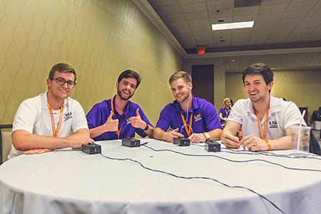 Four LSU students at a round table pose with buzzers used for Chemical Engineering Jeopardy