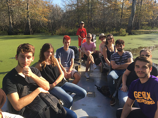 Students from the LSU College of Engineering and visiting engineering students from Polytechnique Universitaire in Lyon, France sit in a tour boat in a swamp