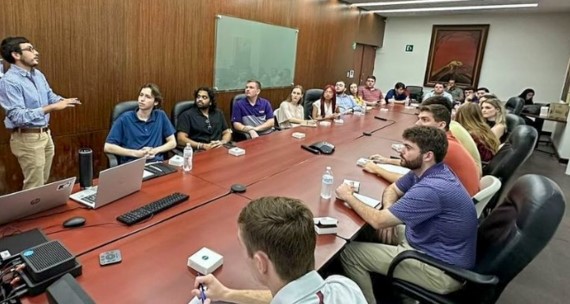 a group of people sit around a long conference table