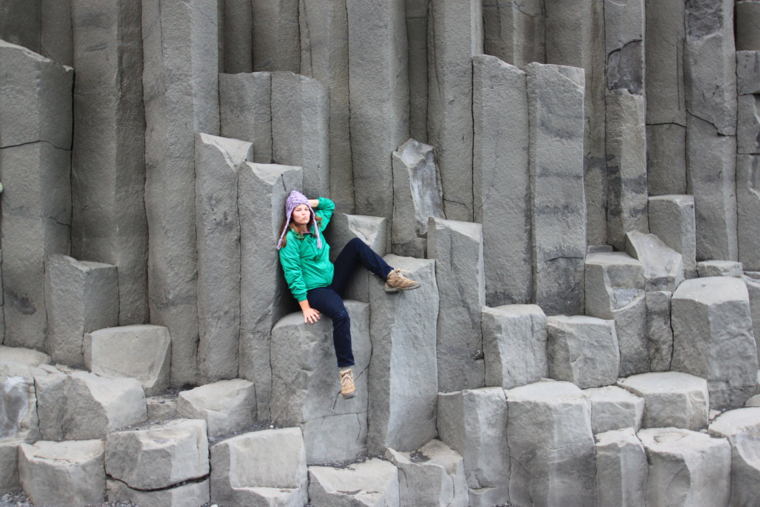 Abigail Heath sitting on hexagonal basalt columns.