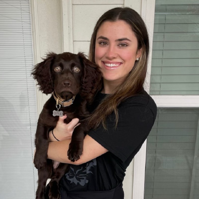 Madison Konur poses with a black dog. 