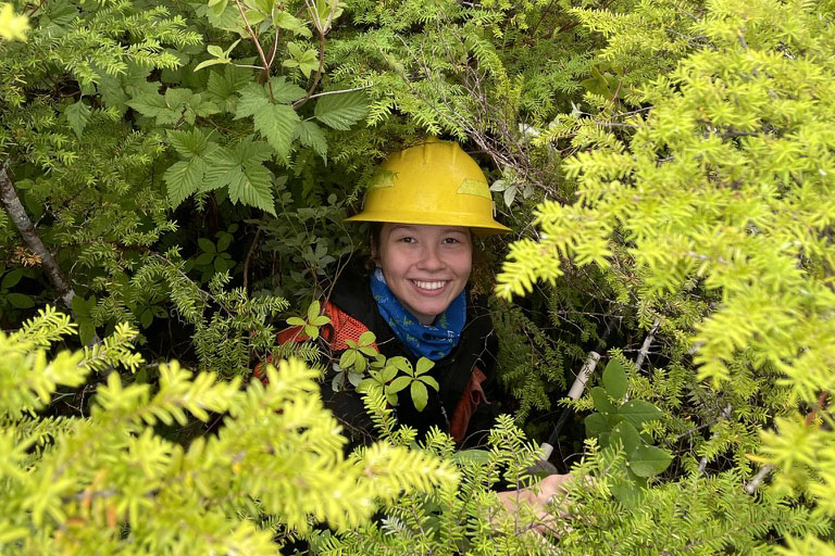 Elizabeth Cuccio with safety gear in bushes