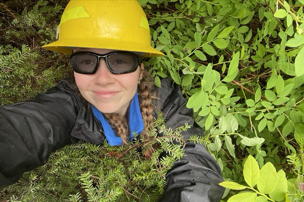 Elizabeth Cuccio with safety gear in bushes