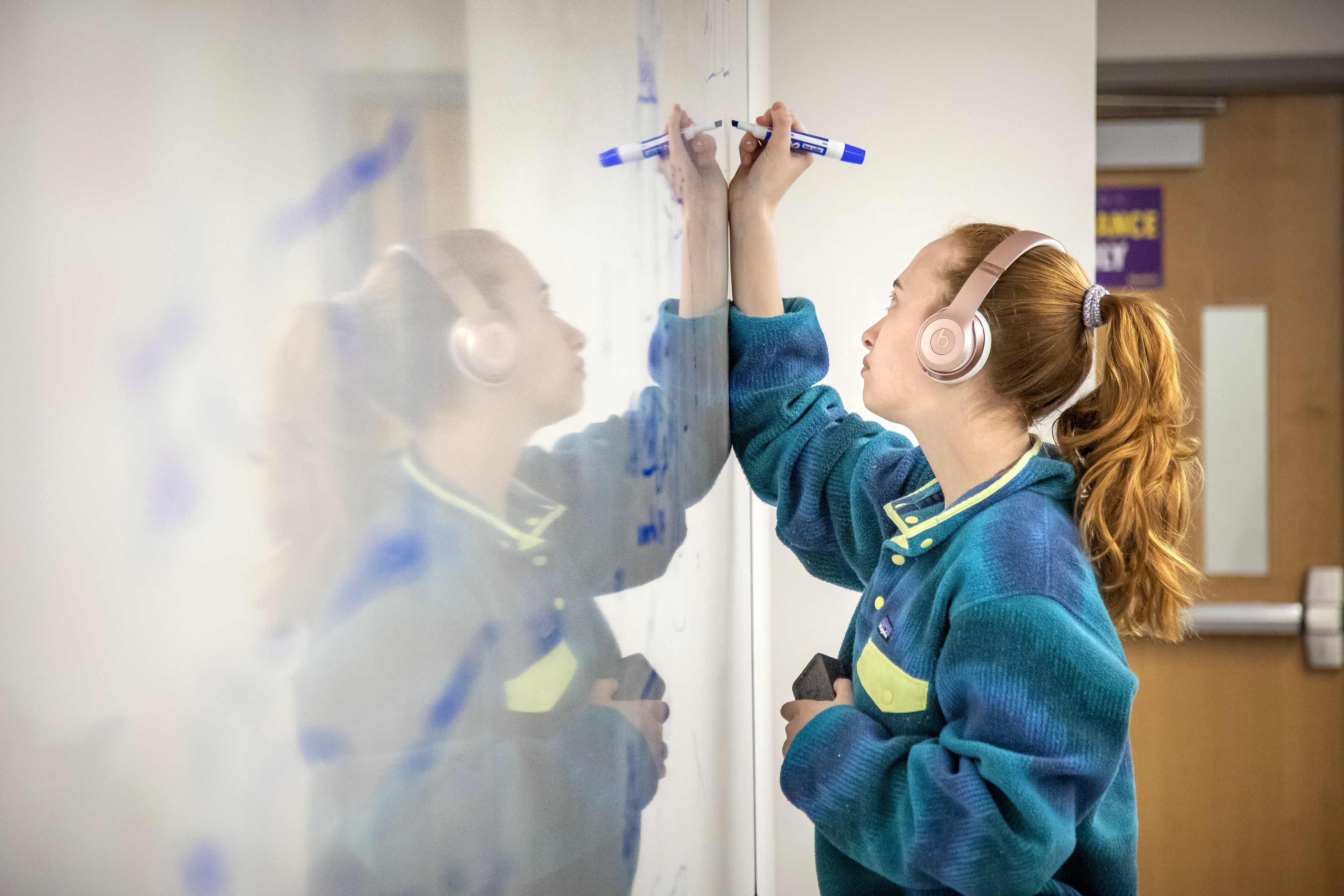 Engineering student works at a white board