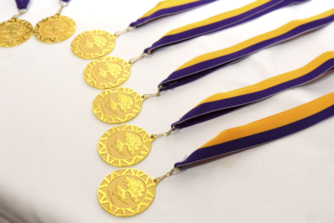gold ECP medals with purple and yellow ribbons lie on a white tablecloth