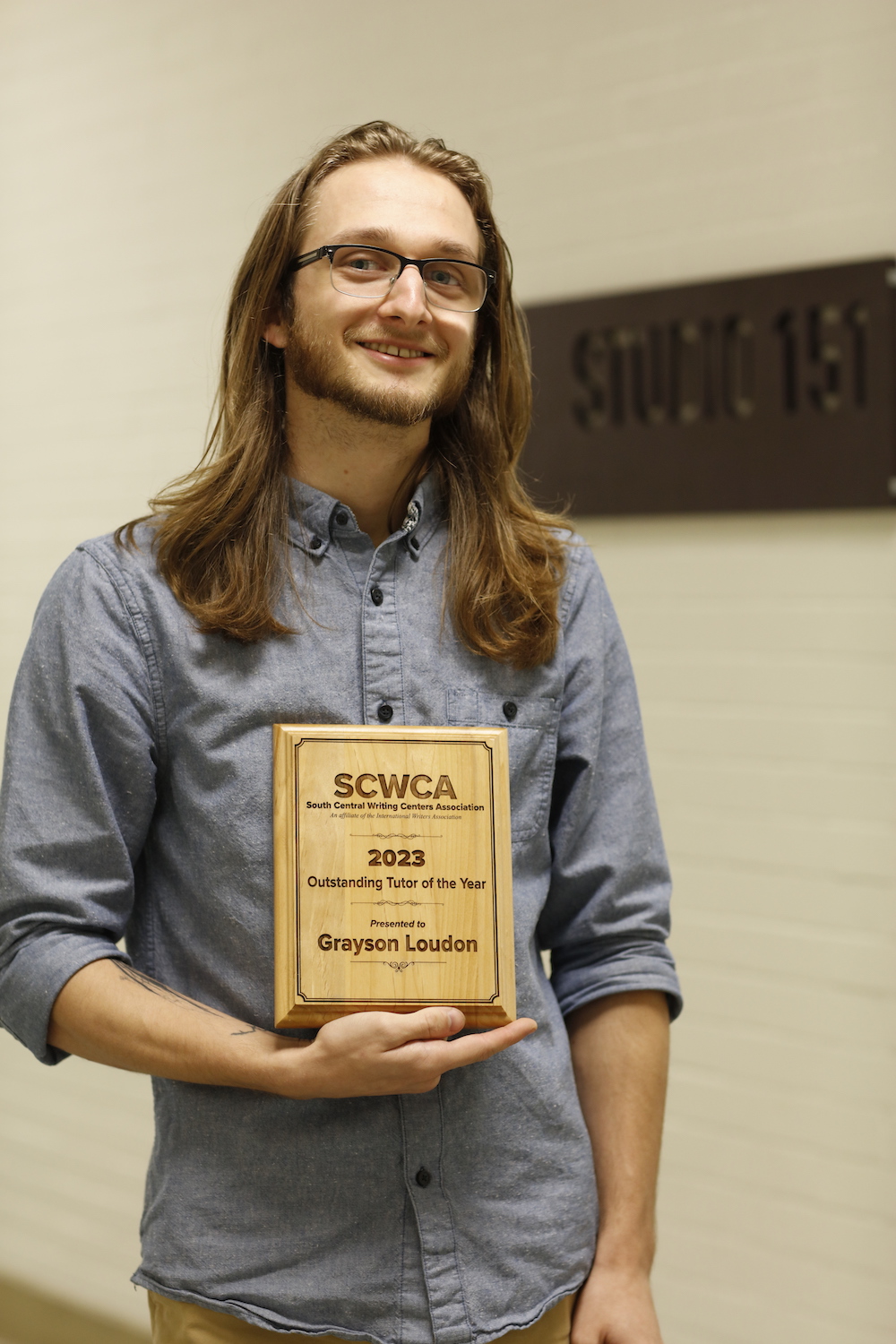 Grayson Loudon holding SCWCA Award plaque for Tutor of the Year