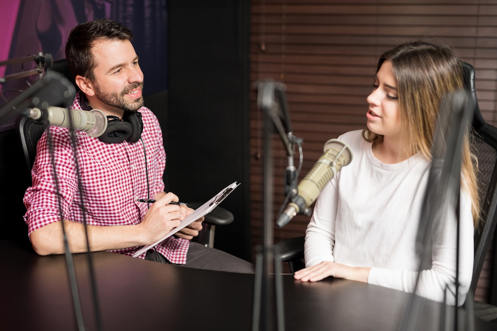 a man interviewing a woman for a podcast