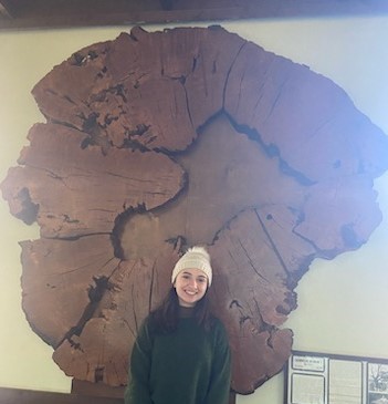 Abby Ligon stands in front of giant oak tree trunk