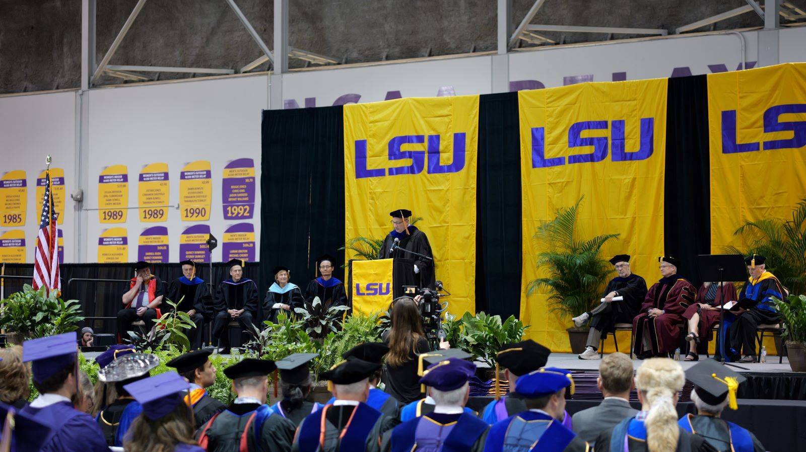 Dean Lee speaking to graduates on a podium 