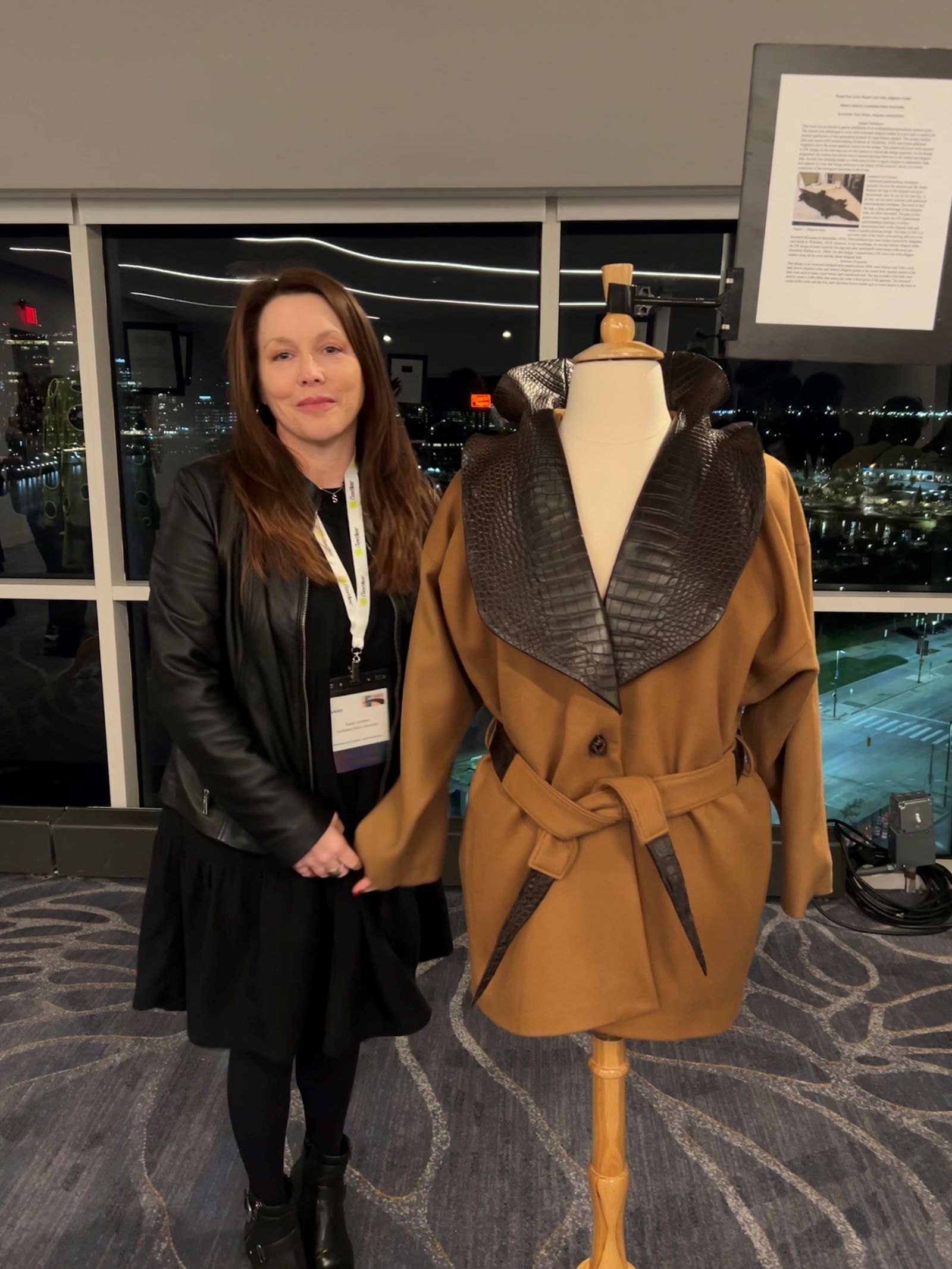 Susan Lindrew stands by her zero waste coat at a research conference.