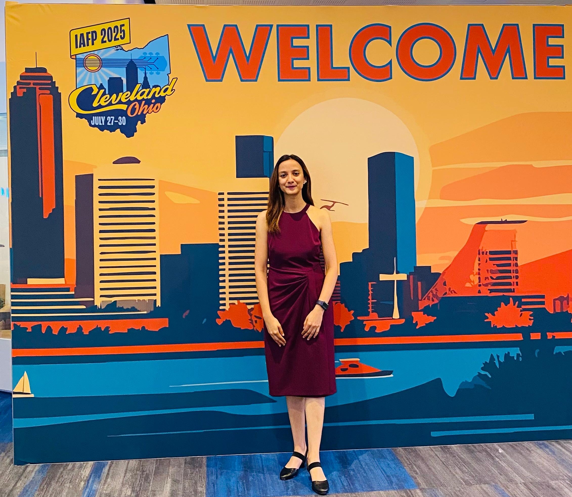 Woman posing in front of a banner.