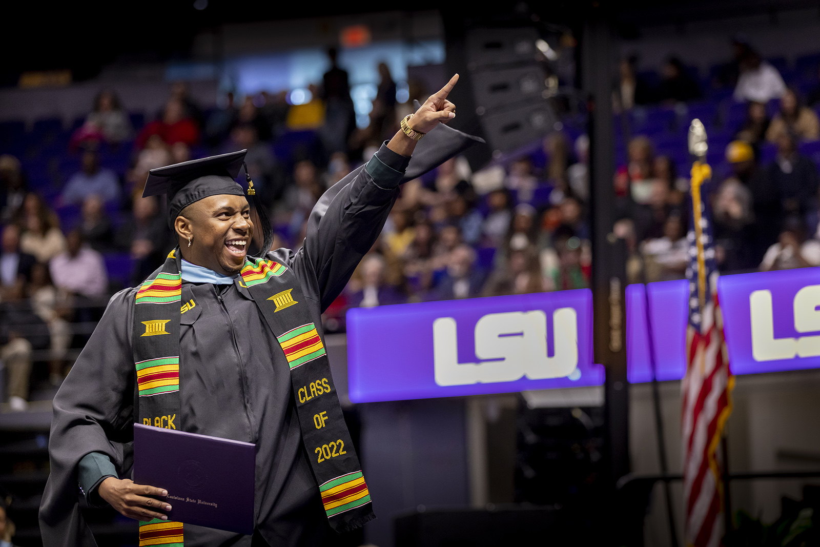 happy graduate points during LSU's fall commencement