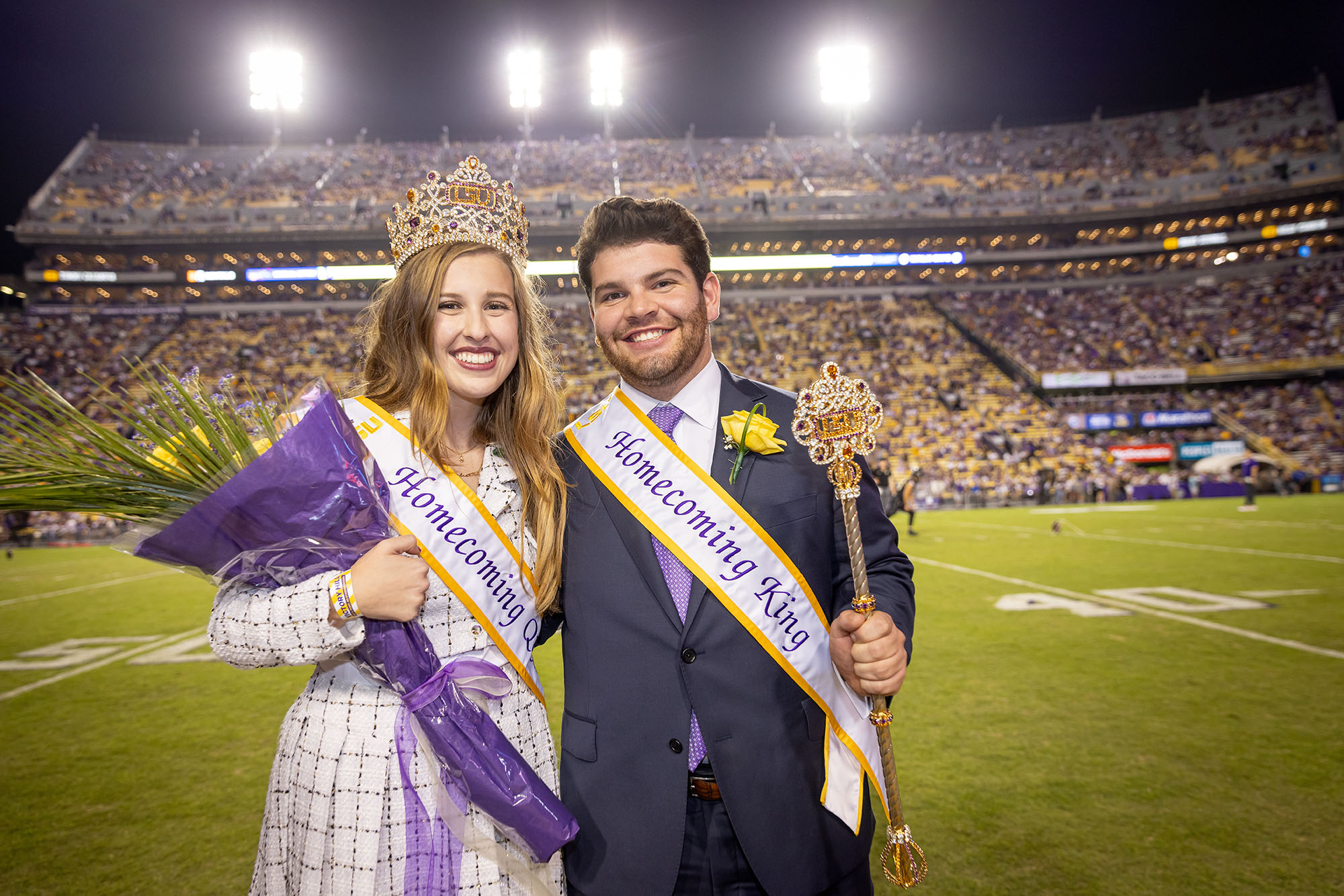 2023 Homecoming king and queen on football field sideline