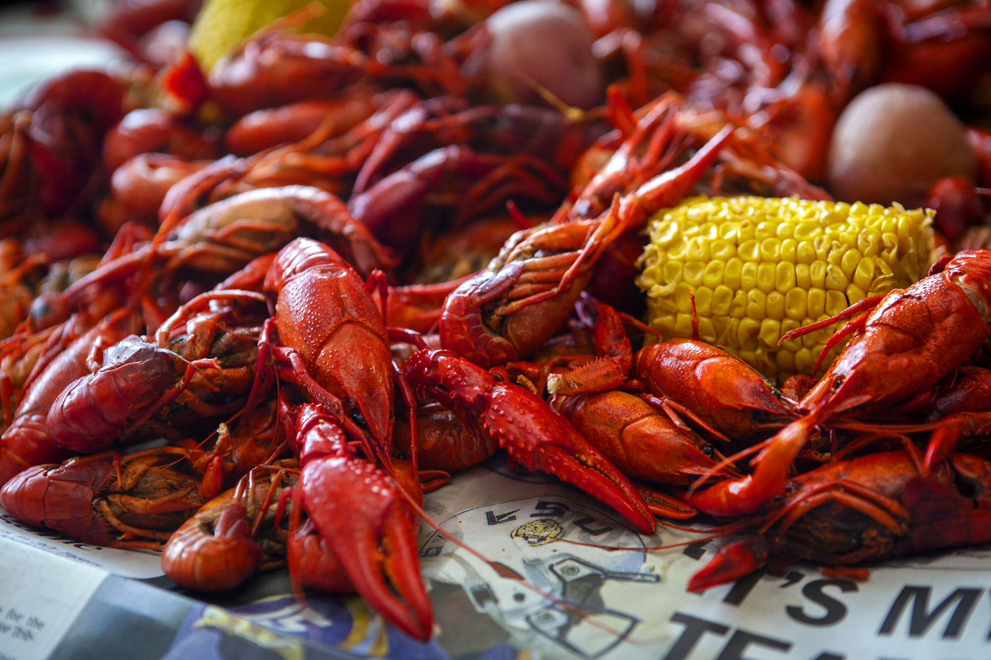 stack of boiled crawfish and corn on newspaper
