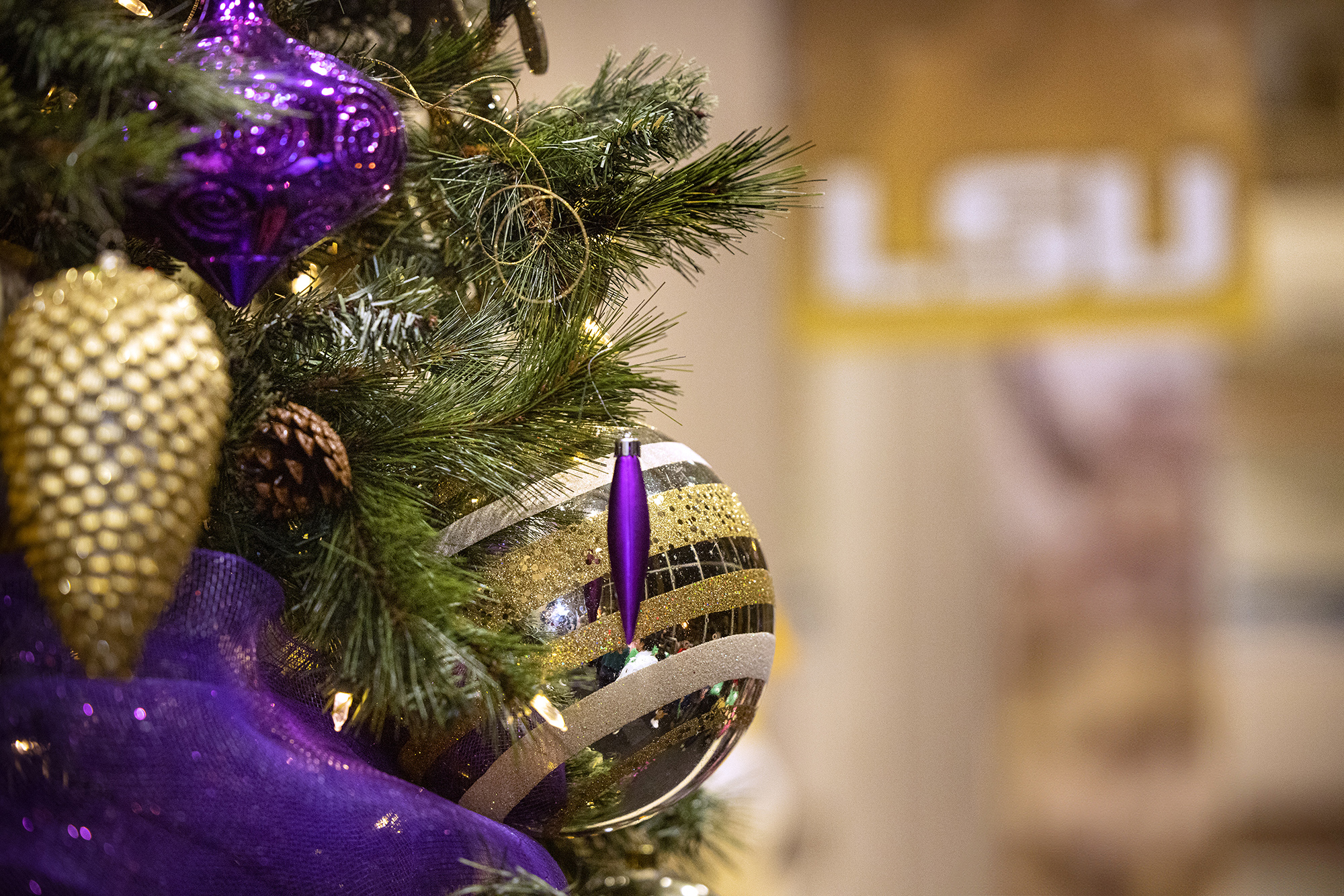 Purple and gold decorations in a close-up on the LSU holiday tree