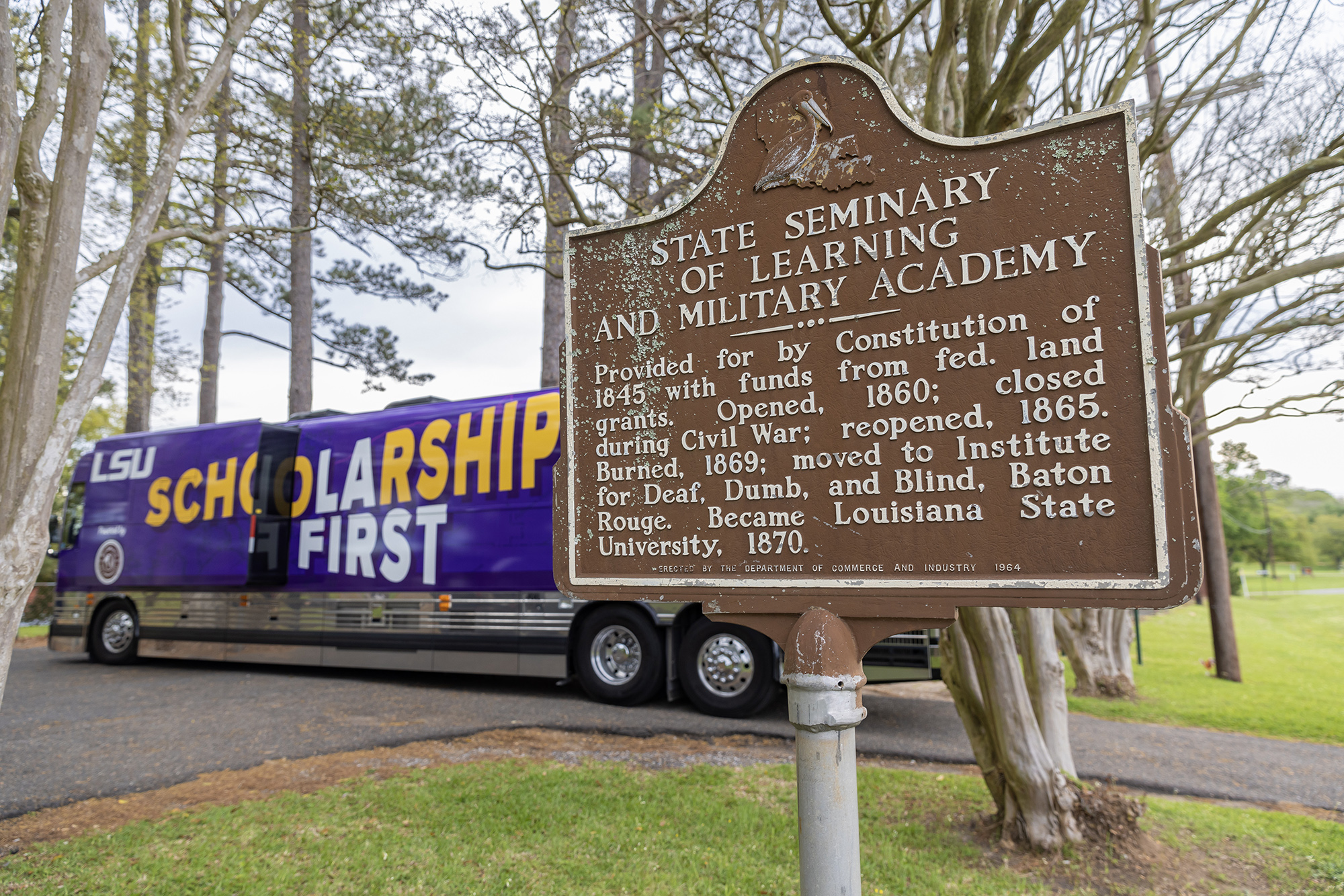  Bus parked near sign marking the original site of the LSU campus