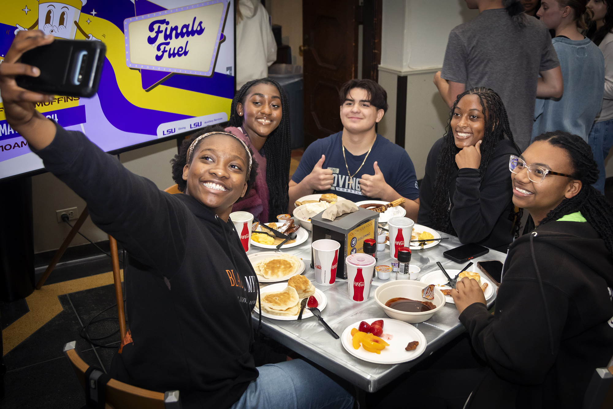 Students at table take selfie during the President's Late Night Breakfast