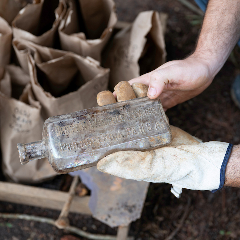Gloved hands holding bottle