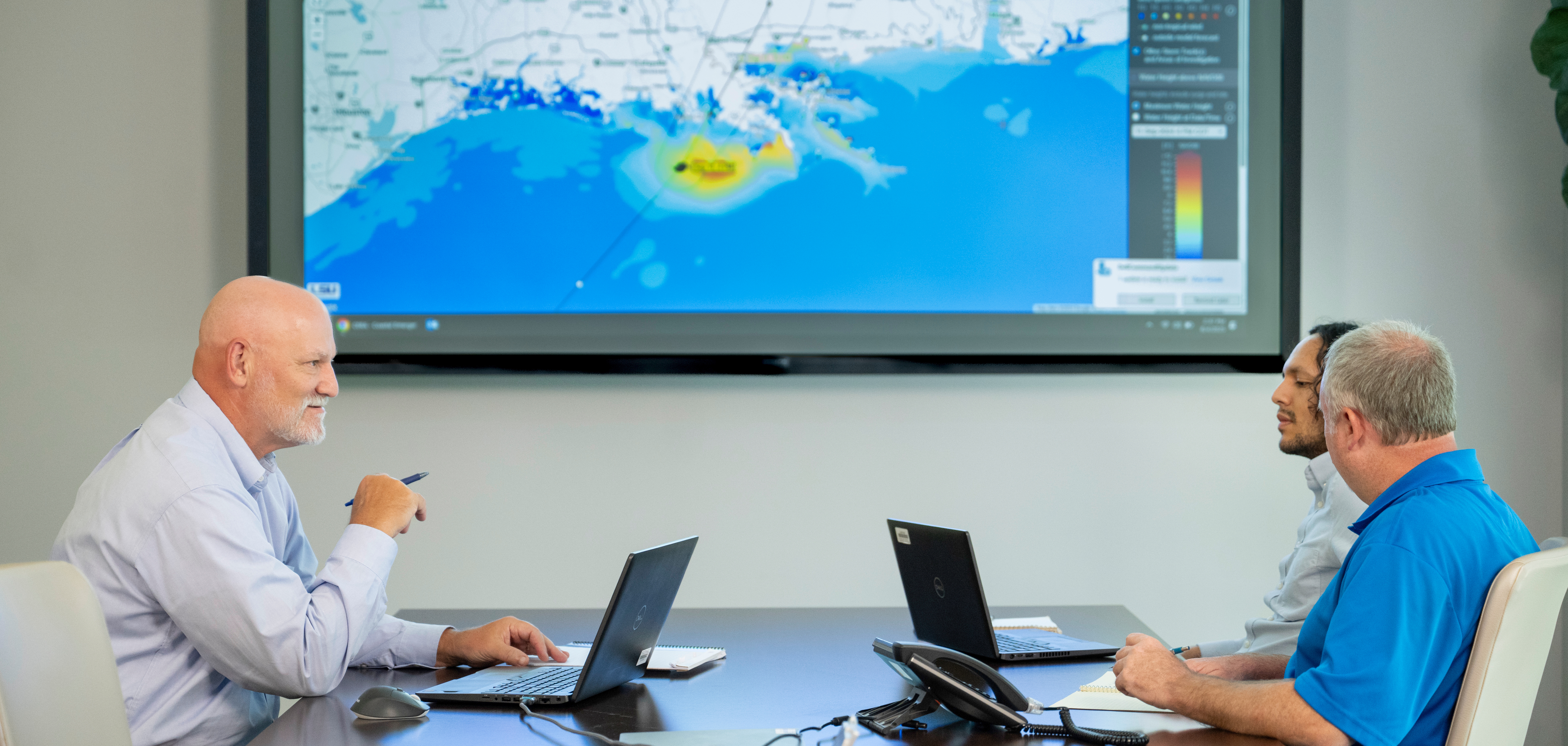 Gregory Grandy and CPRA staff members at a table with the CERA tool on a screen in the backdrop