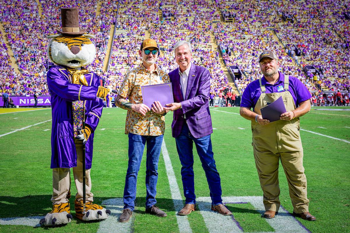 LSU mascot Mike the Tiger, LSU President Wade Rousse and two LSU facility members honored on the football field