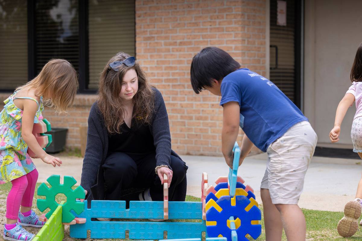 Children play with a teacher at the LSU Preschool