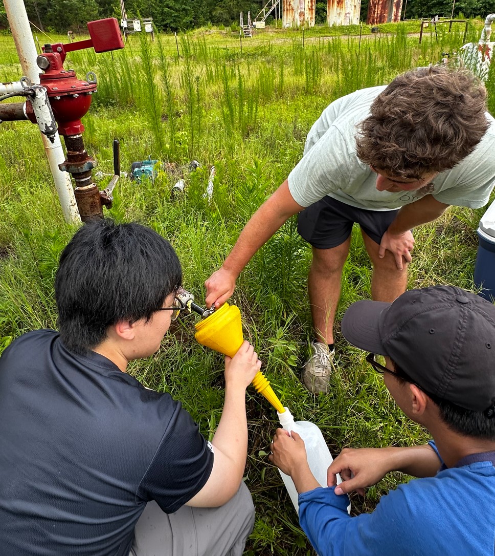 Petroleum Engineering Graduate Assistant Ruoqin Pei and students Walter Scheuermann and Tan Nguyen take brine samples from a well in the Smackover Formation.
