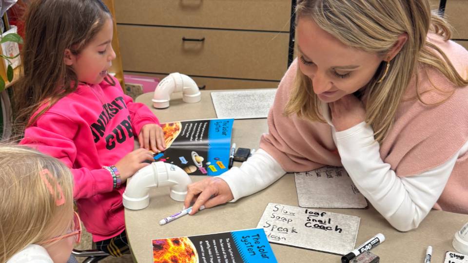 A teacher works with two students