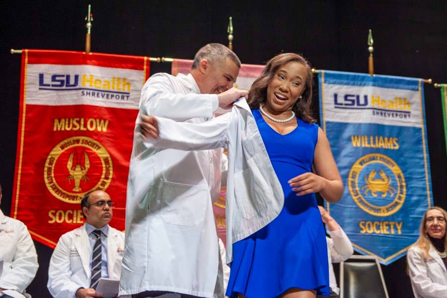 A medical student receives her white coat during a White Coat Ceremony through LSU Health Shreveport