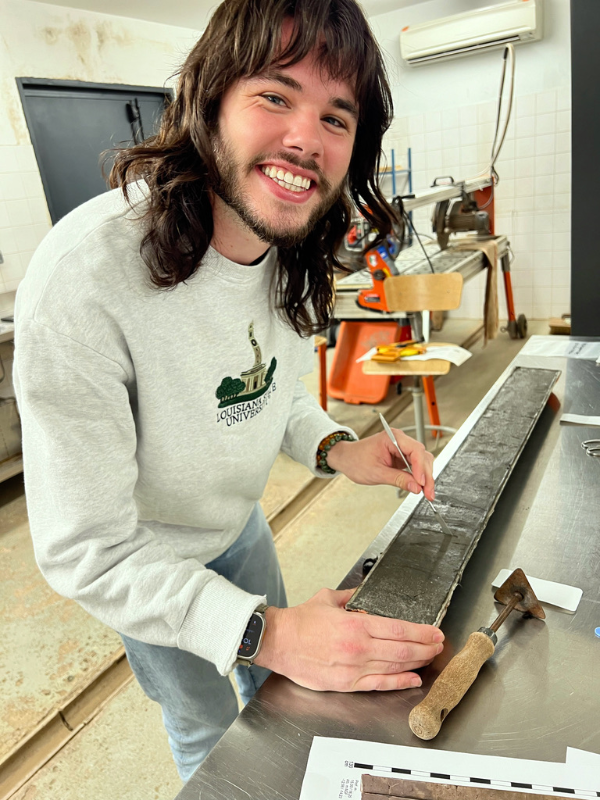 Tristan Ilgenfritz stands along a rocky coastline, reflecting his passion for studying Earth’s natural landscapes.