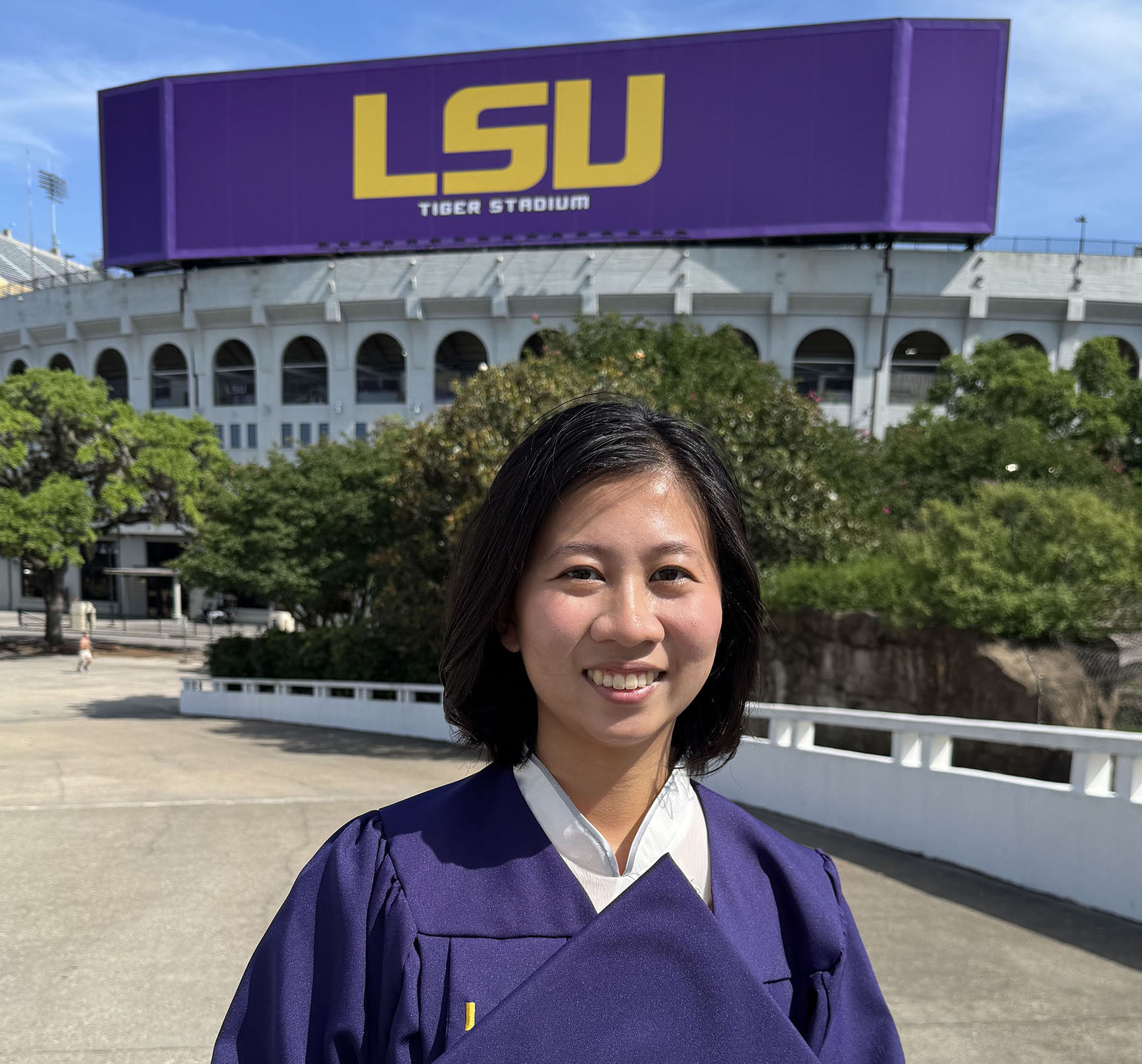 Emma Tsai in cap and gown on LSU campus