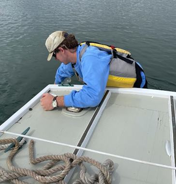 Philip Brahana collects water samples  from a boat