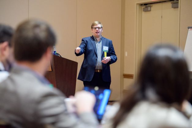 Wes Ladd, LSU alumnus, teaches professionals about cybersecurity at a conference held in a hotel ballroom.