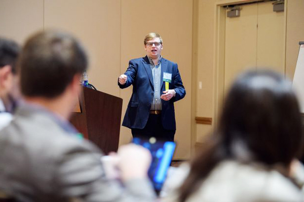 Presenter at a conference speaks will attendees watch.