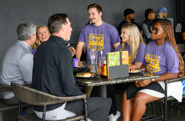 Professional talks with sales student at Top Golf