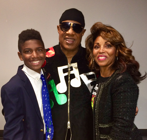 Sonja Wiley and Stevie Wonder stand with a young man