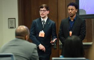 Daniel Lichowid Jr, left, presents to judges, detailing a solution to a pressing cyber threat.