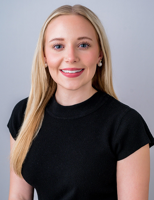 Jaida Johnson headshot taken in a studio. She smiles warmly and wears a black top. 