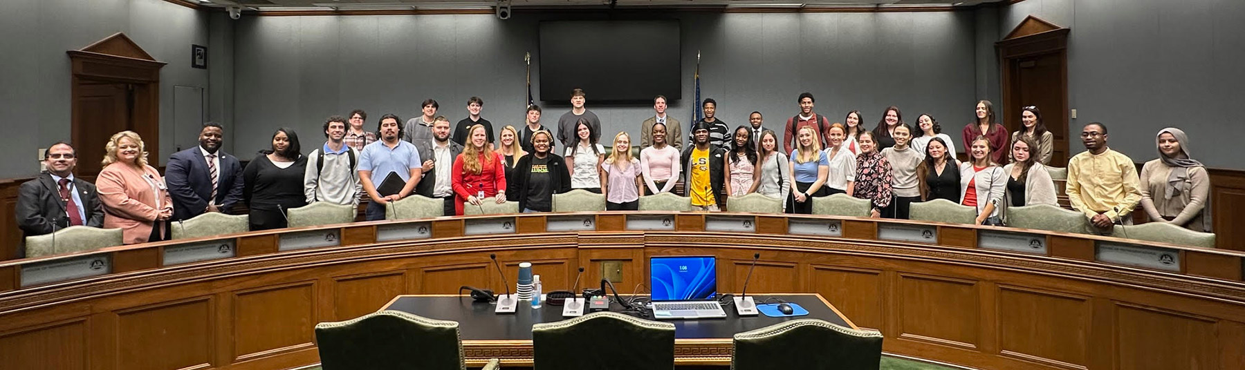 A group of students in the public affairs minor gather in a hearing room within the Louisiana Capitol