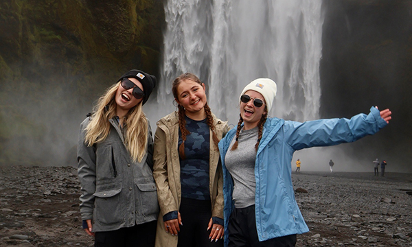 Isabelle Lehr and two other students stand in front of waterfall in Icelane.
