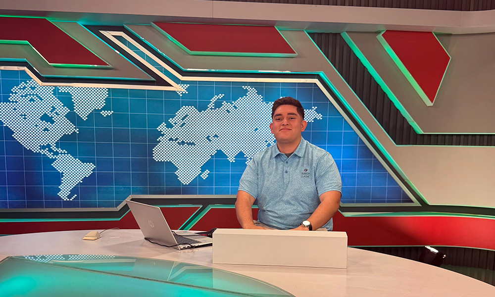 Joseph Perez sits at a news desk in Taiwan.
