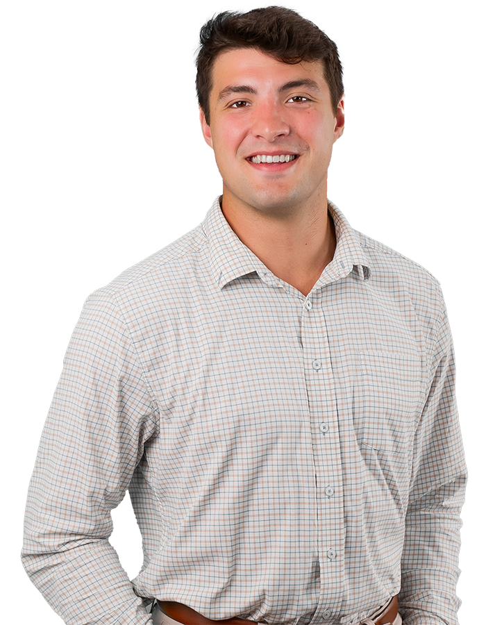 Alex Doga has a warm smile in this headshot. He wears light khakis and a patterned dress shirt.