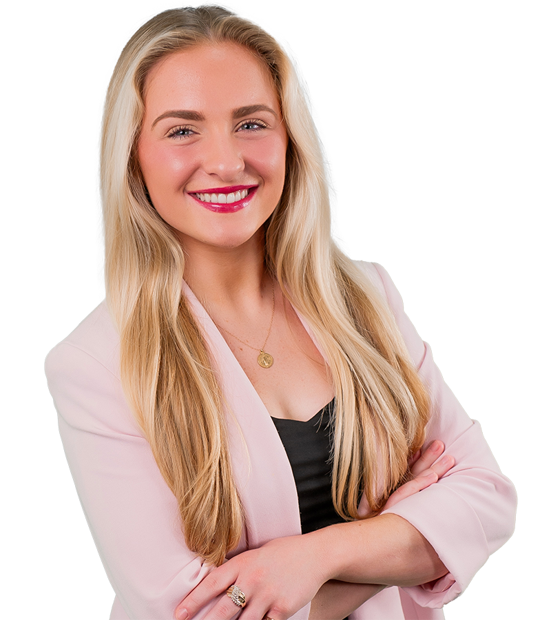 Chloe Chehardy's long blonde hair is smooth in this headshot. She wears a pale pink blazer and black shirt.