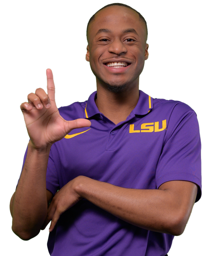 Clarence Magee wears a purple LSU polo. He has a big smile and holds his hand up in an L shape.