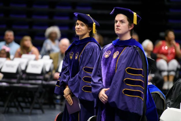 two phd students at graduation ceremony 