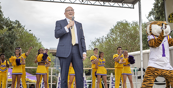 Matt Lee on stage at Fall Fest with cheerleaders and Mike the Tiger