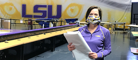 Provost Haynie at PPE site wearing a mask and holding materials