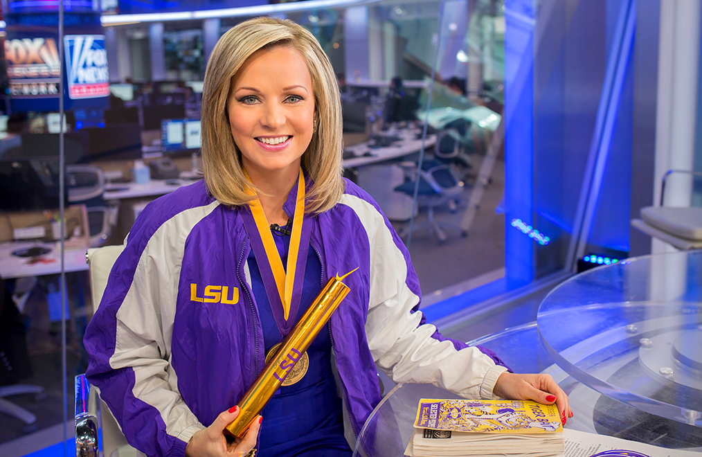 Sandra Smith at her desk wearing athletic jacket and medals