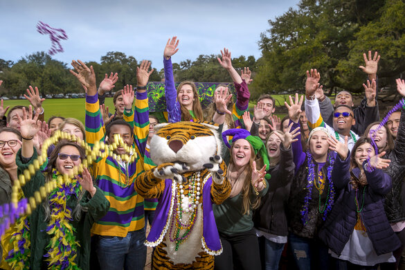Mike the Tiger with students catching Mardi Gras beads on the Parade Grounds