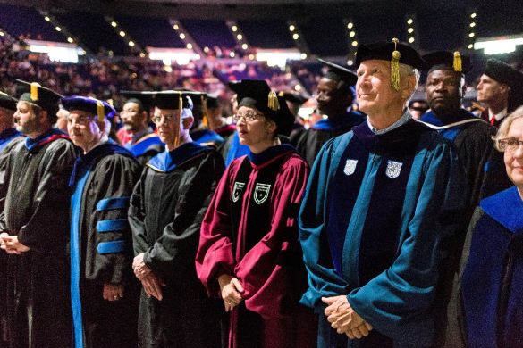 In academic regalia, LSU Faculty stand for recgontion at commencement ceremonies 