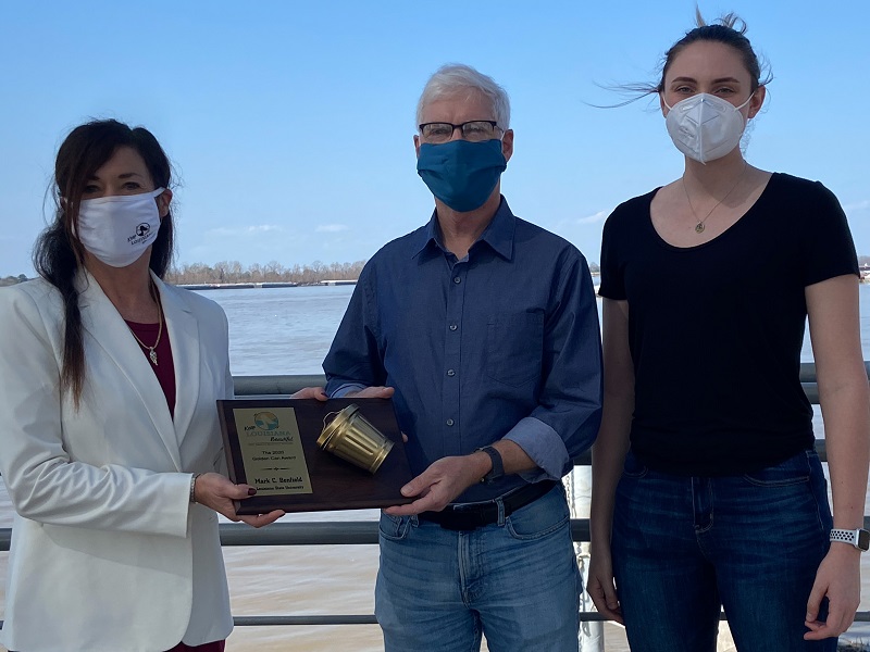 three people pose with a plaque